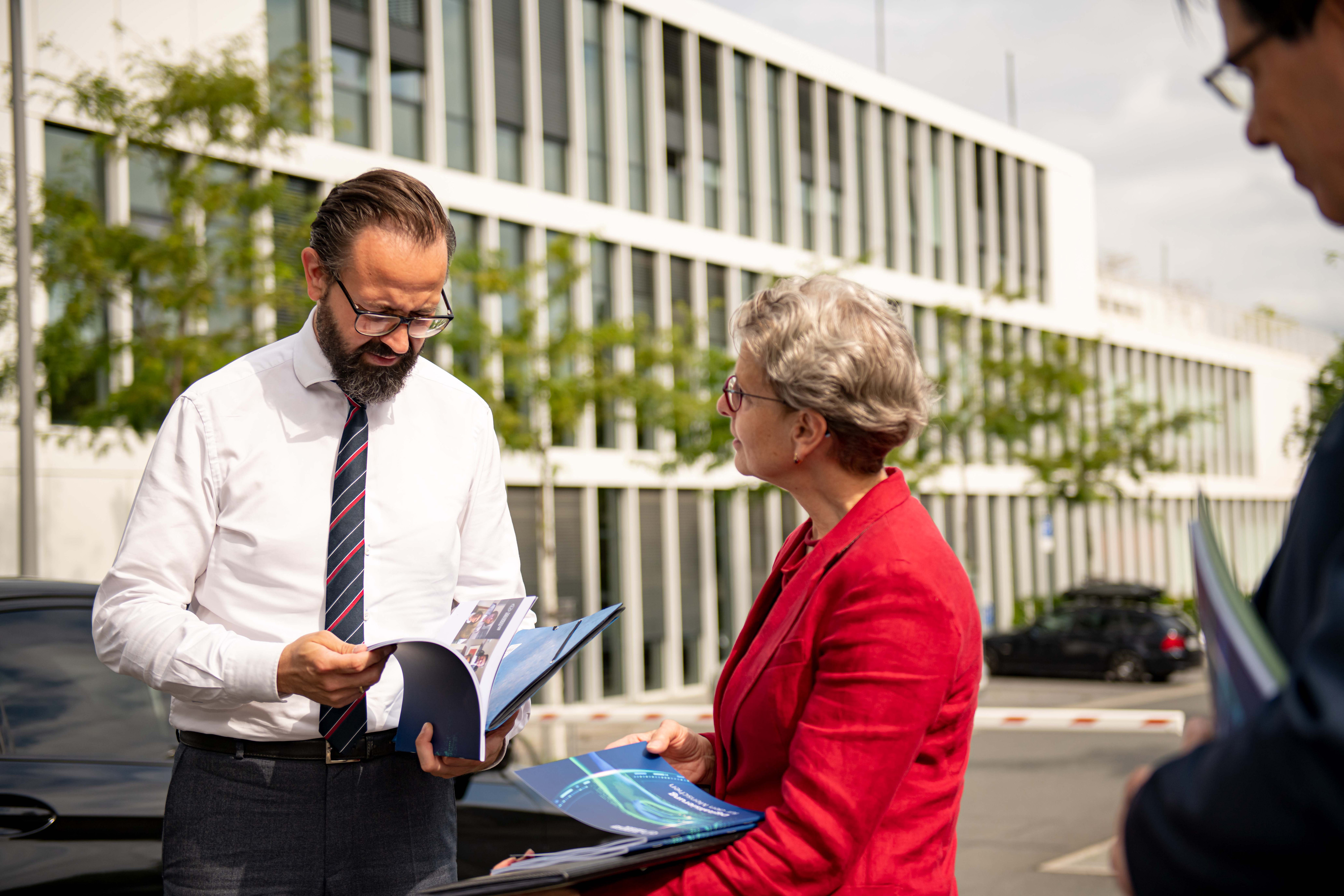 Sachsens Wissenschaftsminister Gemkow bekommt von TU-Dresden-Rektorin Staudinger Broschüren überreicht und blättert darin.